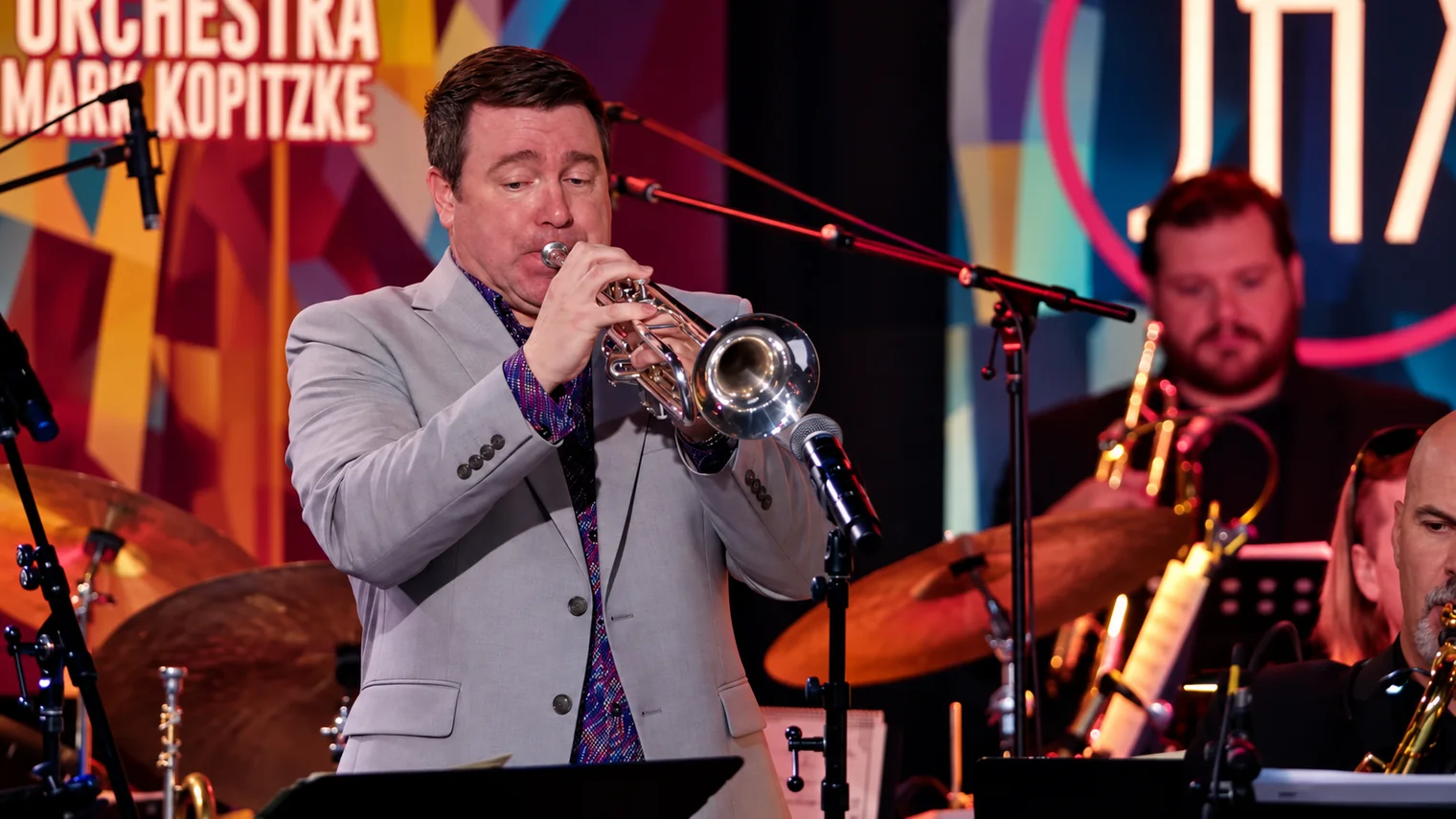 Chad Willis playing trumpet in a gray jacket — approved editorial image
