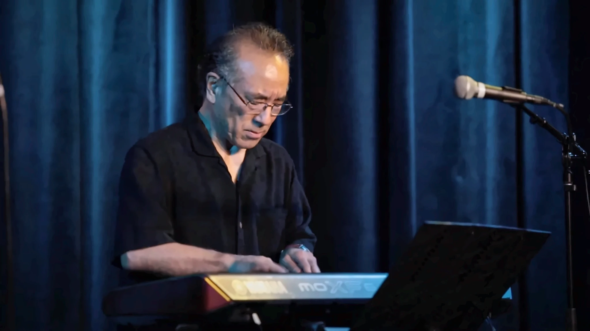 Ron Kobayashi concentrating at the Yamaha keyboard during a Campus JAX performance